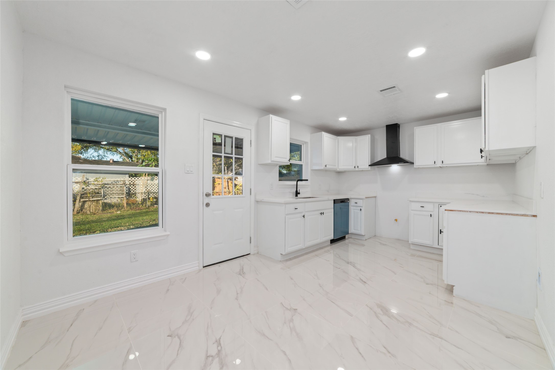 11434 Sharpview Drive Houston, TX 77072 - Photo 9 of 25 a large white kitchen with a sink a window and stainless steel appliances