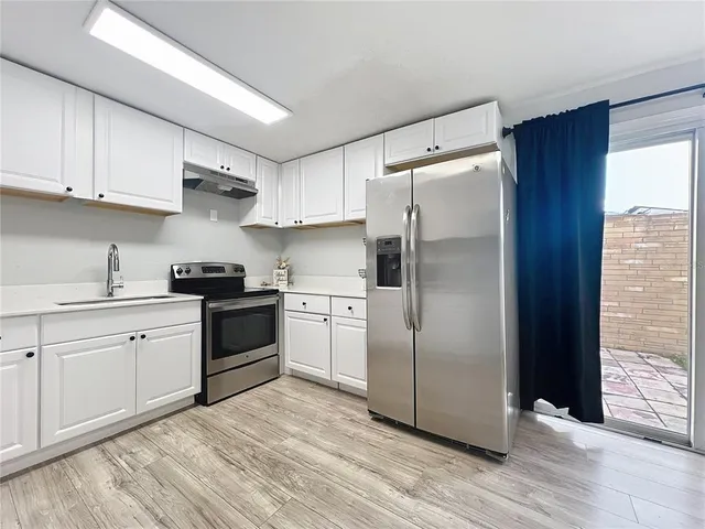 a kitchen with stainless steel appliances a refrigerator sink and cabinets