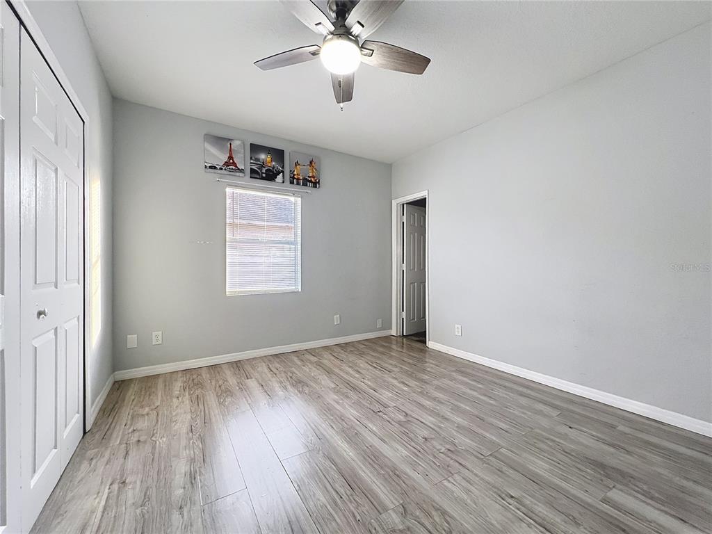 1109 5th Street Southwest Winter Haven, FL 33880 - Photo 13 of 20 an empty room with wooden floor chandelier fan and windows