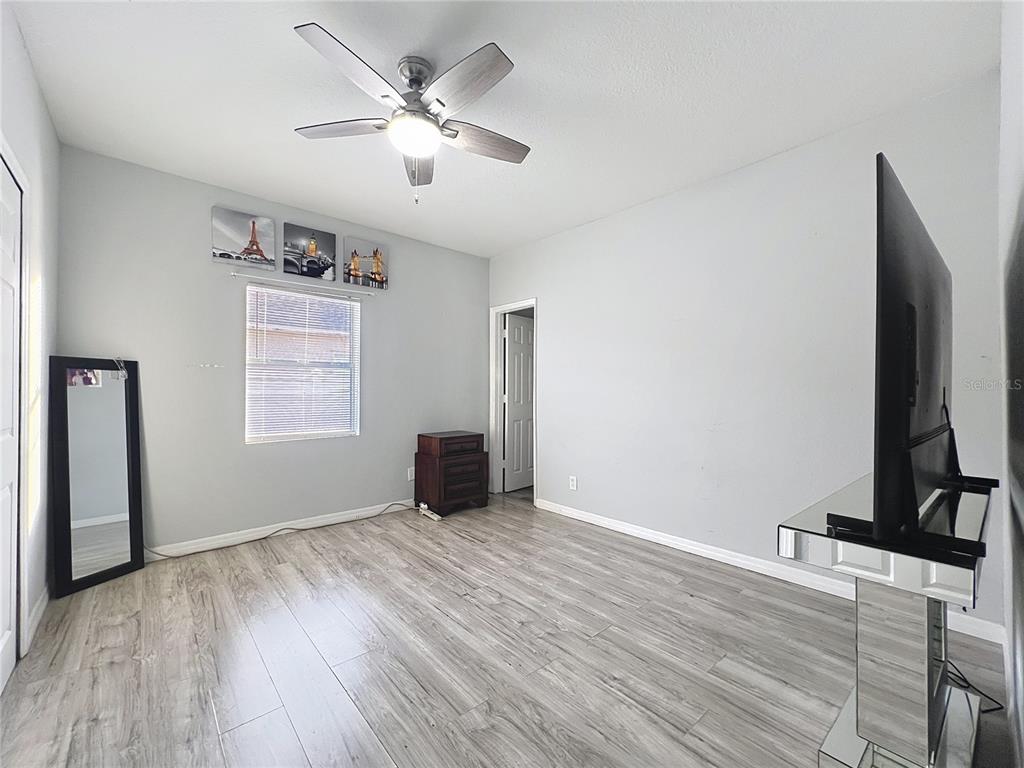 1109 5th Street Southwest Winter Haven, FL 33880 - Photo 15 of 20 an empty room with wooden floor chandelier fan and windows