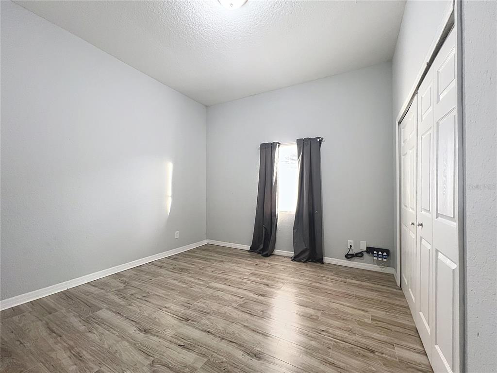 1109 5th Street Southwest Winter Haven, FL 33880 - Photo 18 of 20 a view of an empty room with wooden floor and a window
