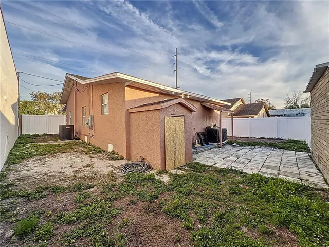 a view of a house with a small yard and wooden fence