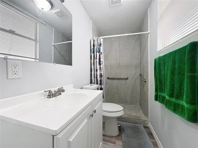 a bathroom with a sink a toilet and shower