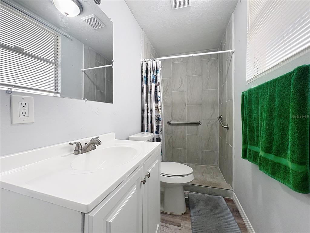 1109 5th Street Southwest Winter Haven, FL 33880 - Photo 8 of 20 a bathroom with a sink a toilet and shower