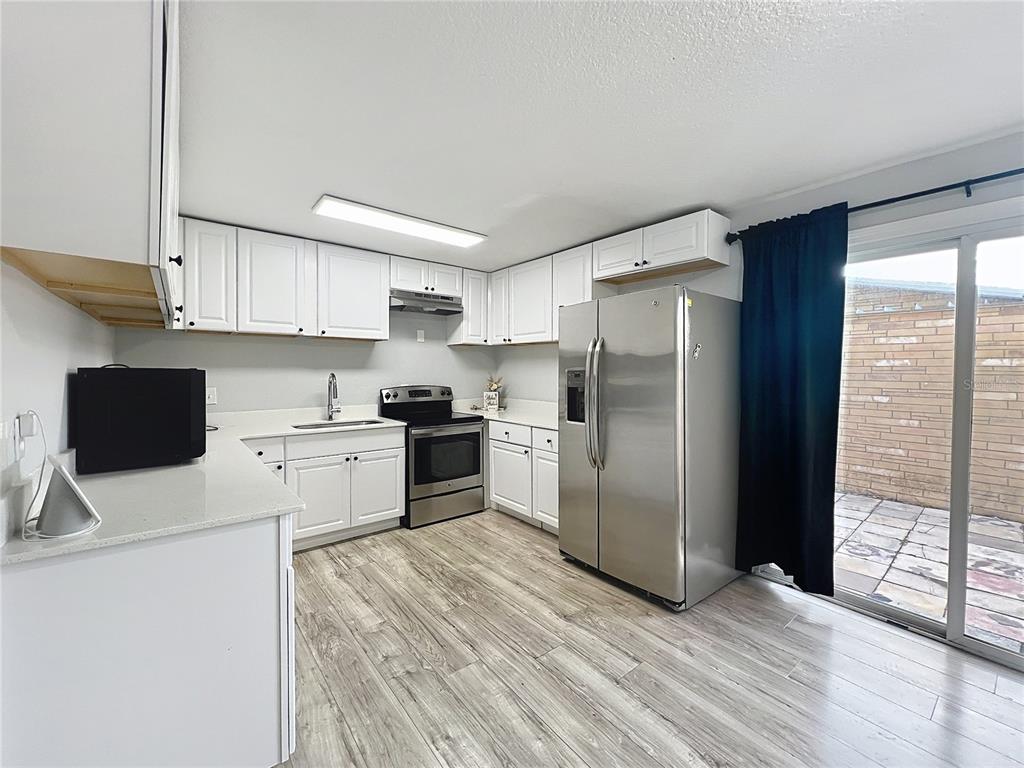 1109 5th Street Southwest Winter Haven, FL 33880 - Photo 9 of 20 a kitchen with granite countertop a refrigerator stove top oven and sink