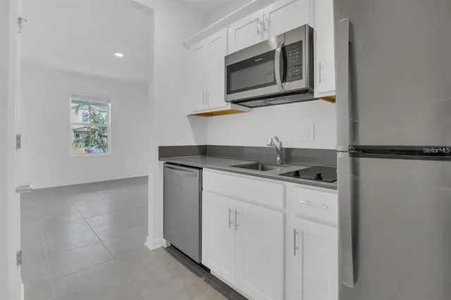 a kitchen with stainless steel appliances granite countertop a sink and a microwave
