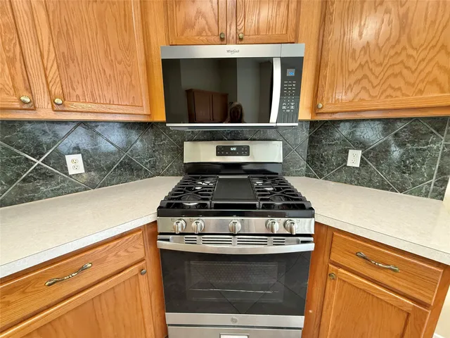 a stove top oven sitting inside of a kitchen