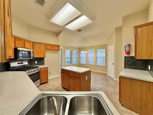 a kitchen with stainless steel appliances granite countertop a sink and a stove