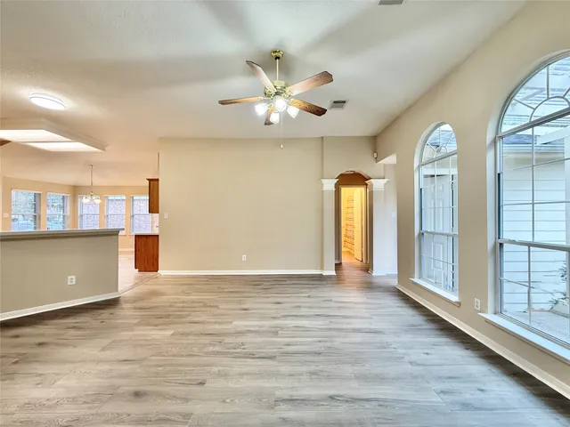 a view of an empty room with window and wooden floor