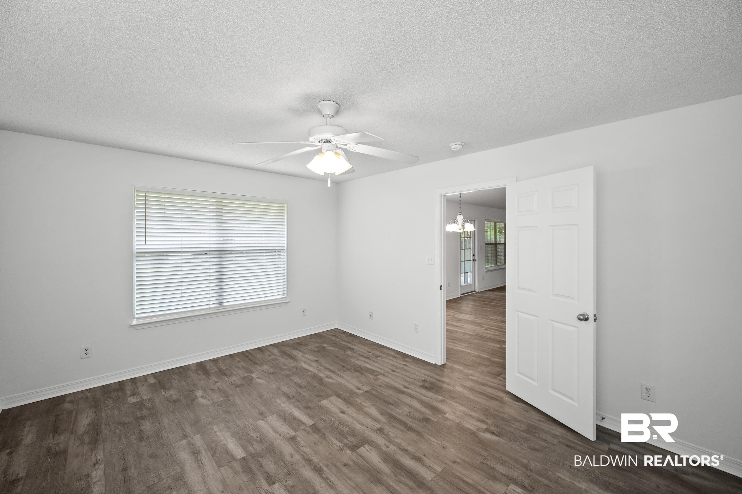 306 Monteith Oaks Drive Foley, AL 36535 - Photo 13 of 38 Unfurnished room with a ceiling fan, dark wood-style flooring, a chandelier, and a textured ceiling