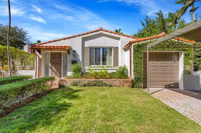 a view of a house with brick walls and a yard with plants