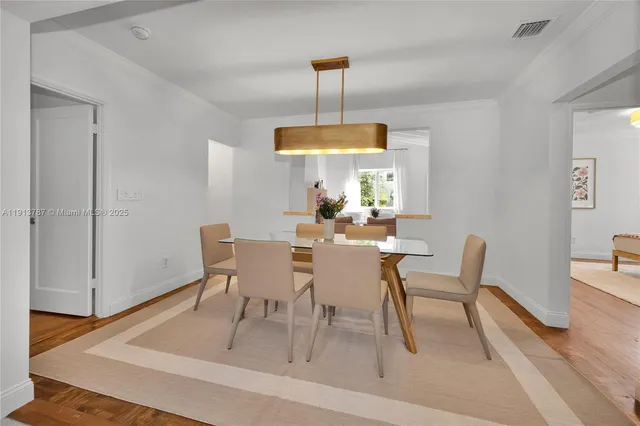 a dining room with furniture a chandelier and wooden floor