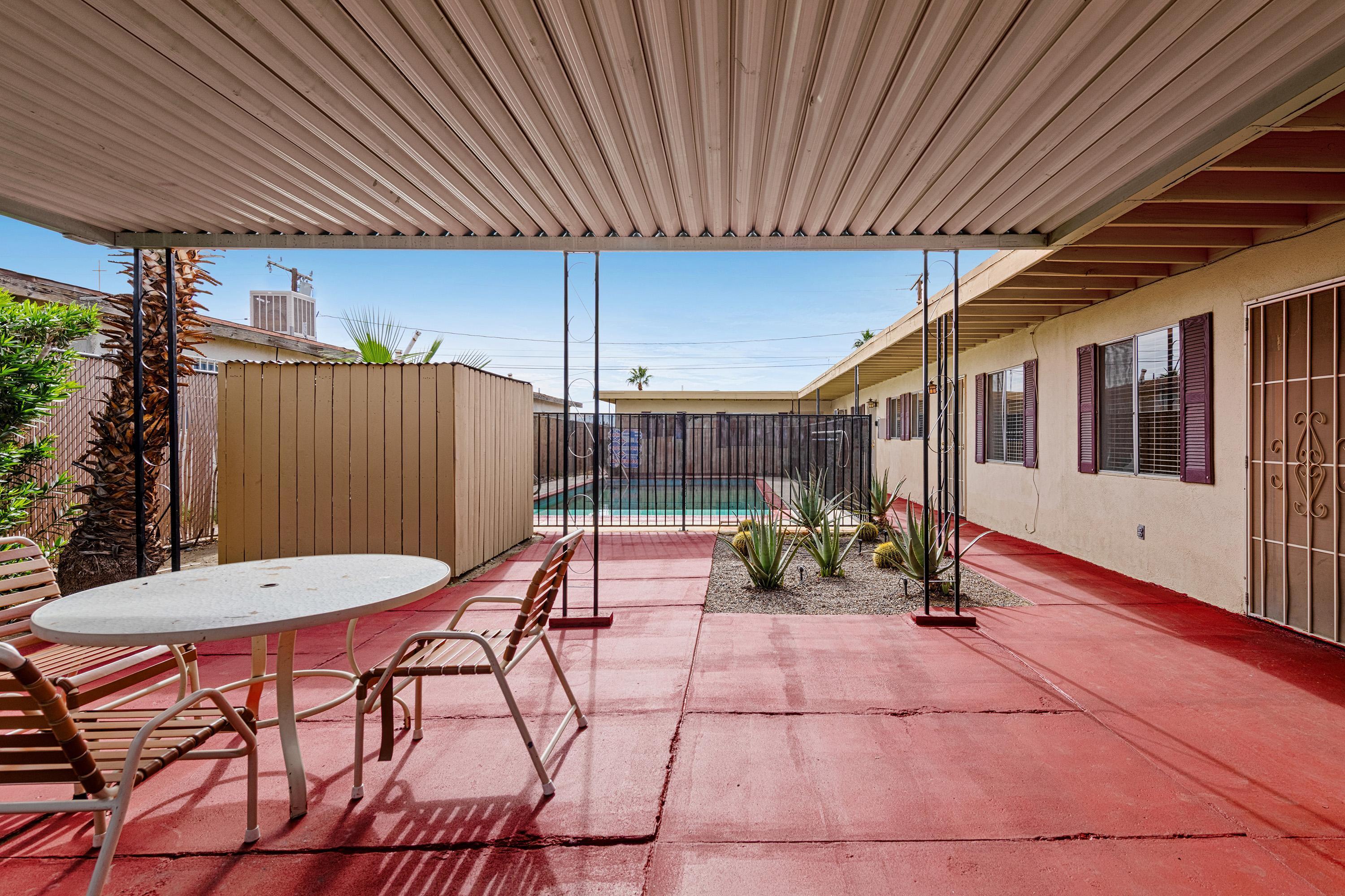 66665 First Street Desert Hot Springs, CA 92240 - Photo 3 of 35 a view of a patio with table and chairs with wooden floor and fence