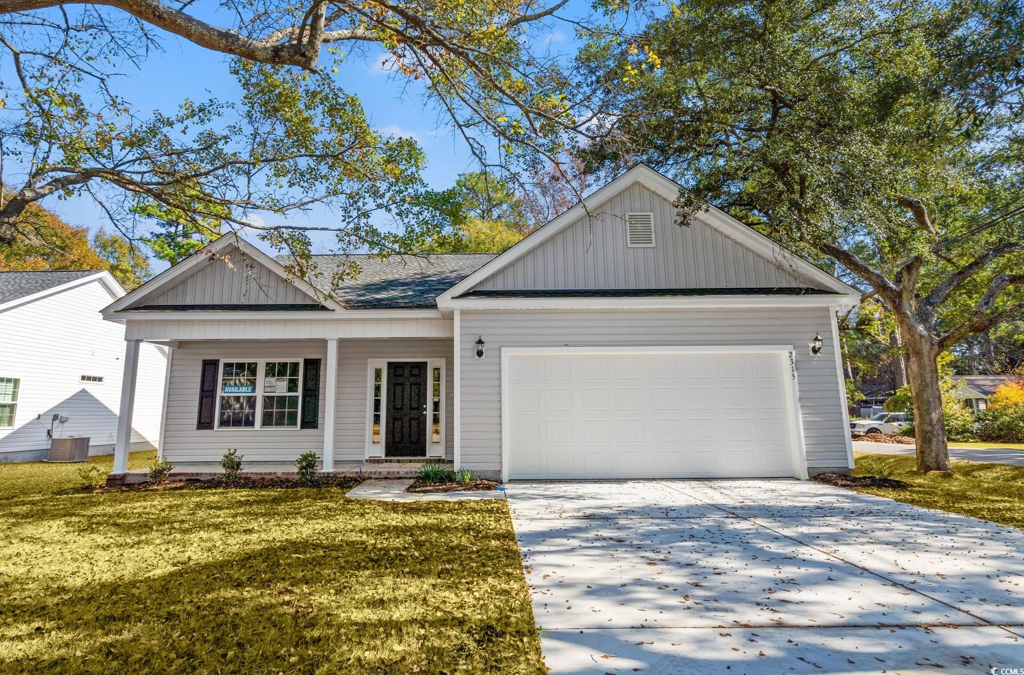 2315 Withers Street Georgetown, SC 29440 - Photo 1 of 29 View of front facade featuring board and batten siding, covered porch, concrete driveway, a front lawn, and a shingled roof