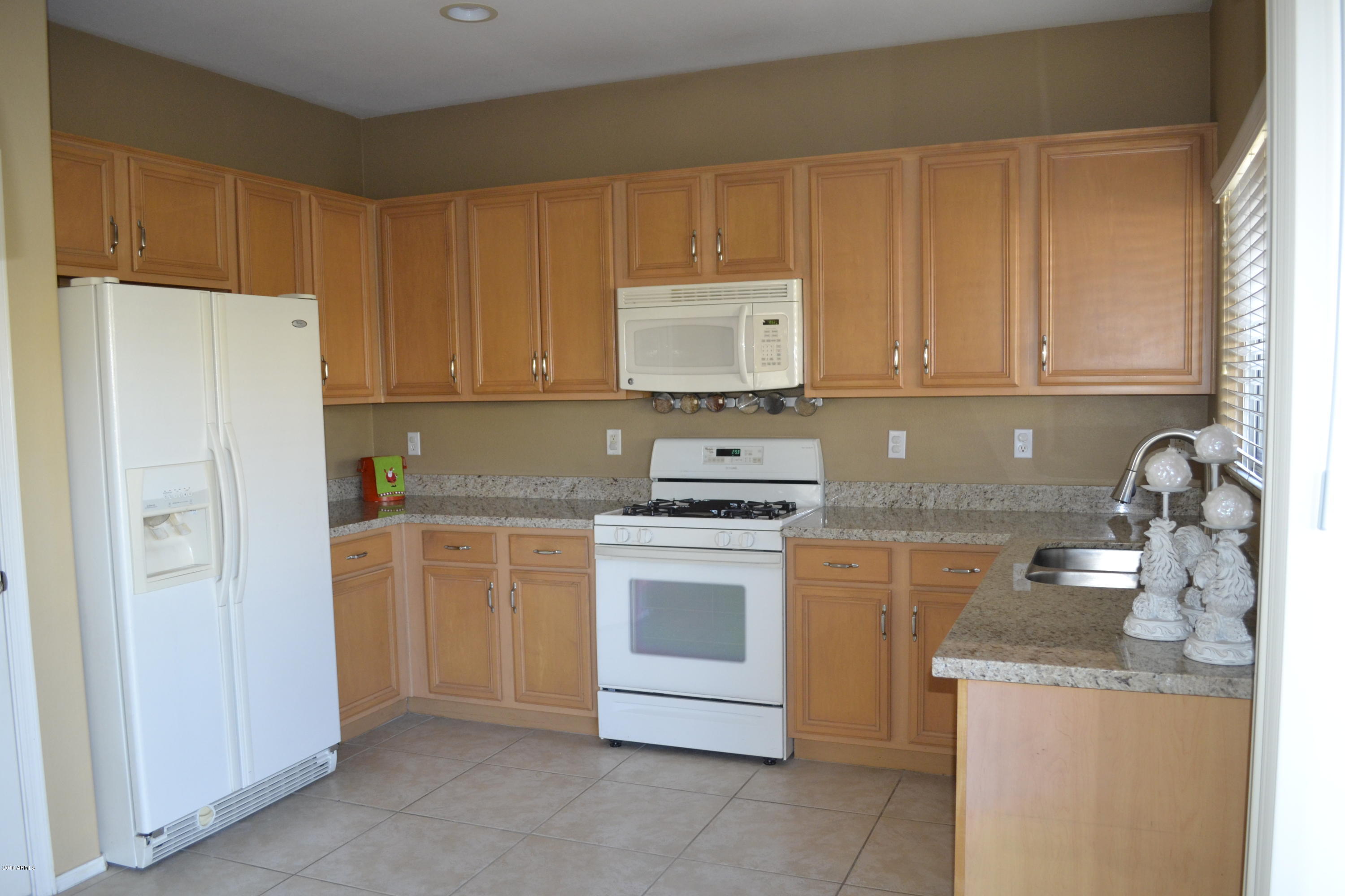 3517 South Sawmill Road Gilbert, AZ 85297 - Photo 12 of 26 a kitchen with cabinets appliances and a window