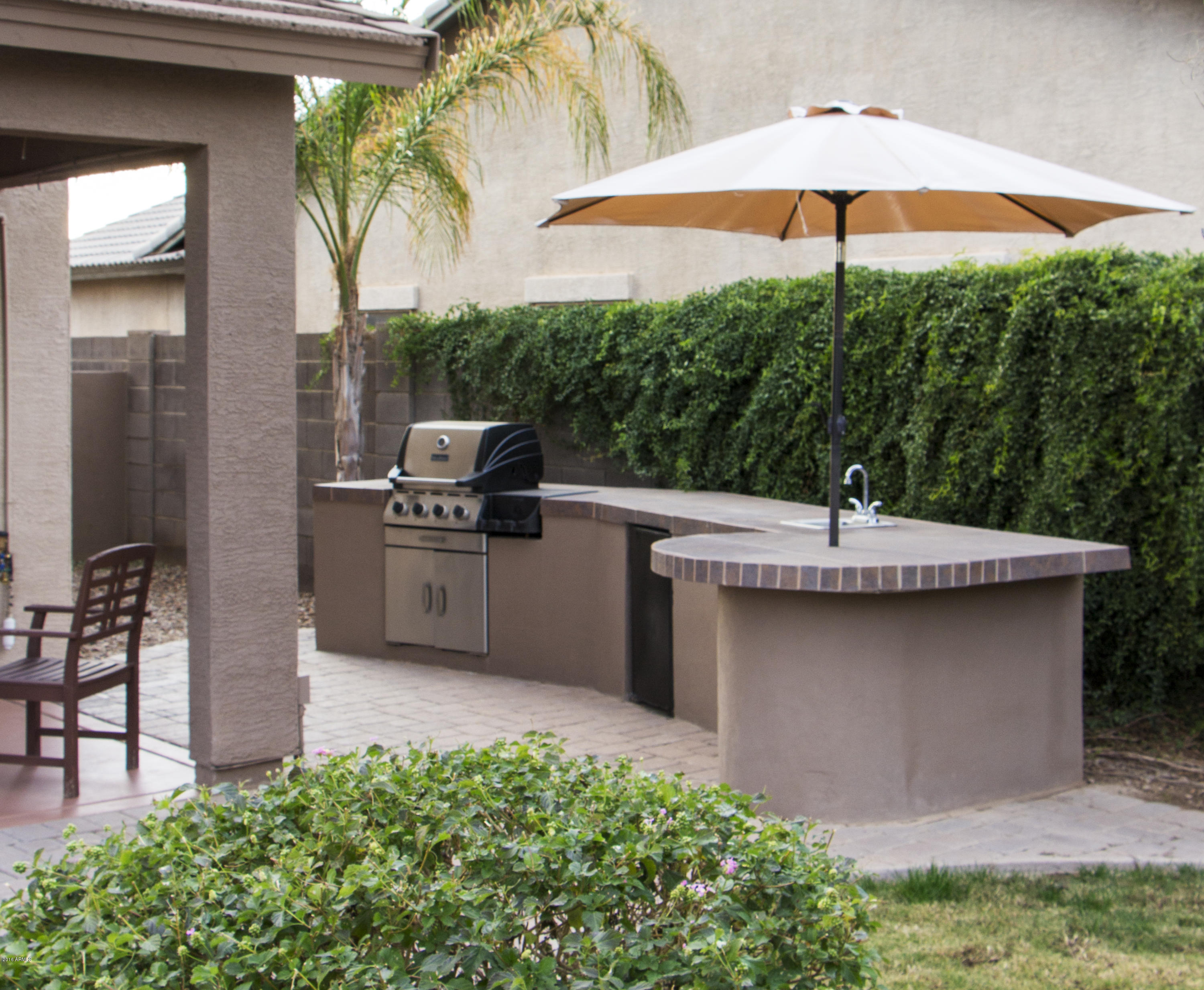 3517 South Sawmill Road Gilbert, AZ 85297 - Photo 4 of 26 a view of a kitchen with a sink and table under an umbrella