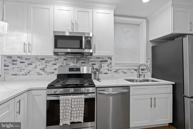 a kitchen with stainless steel appliances granite countertop a stove microwave and sink