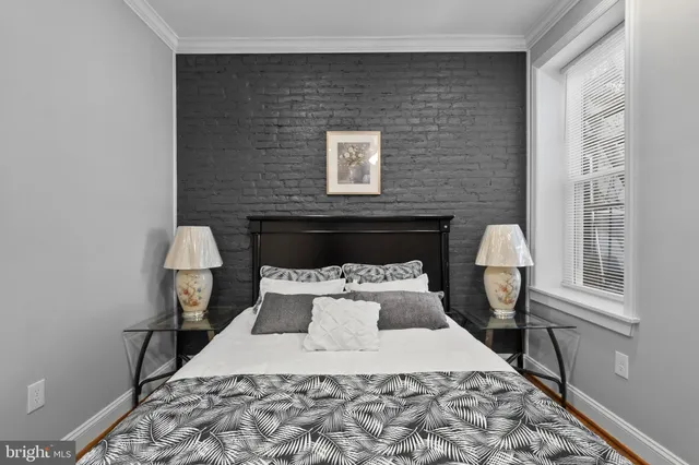 a bed sitting in a bedroom next to a window with lamp