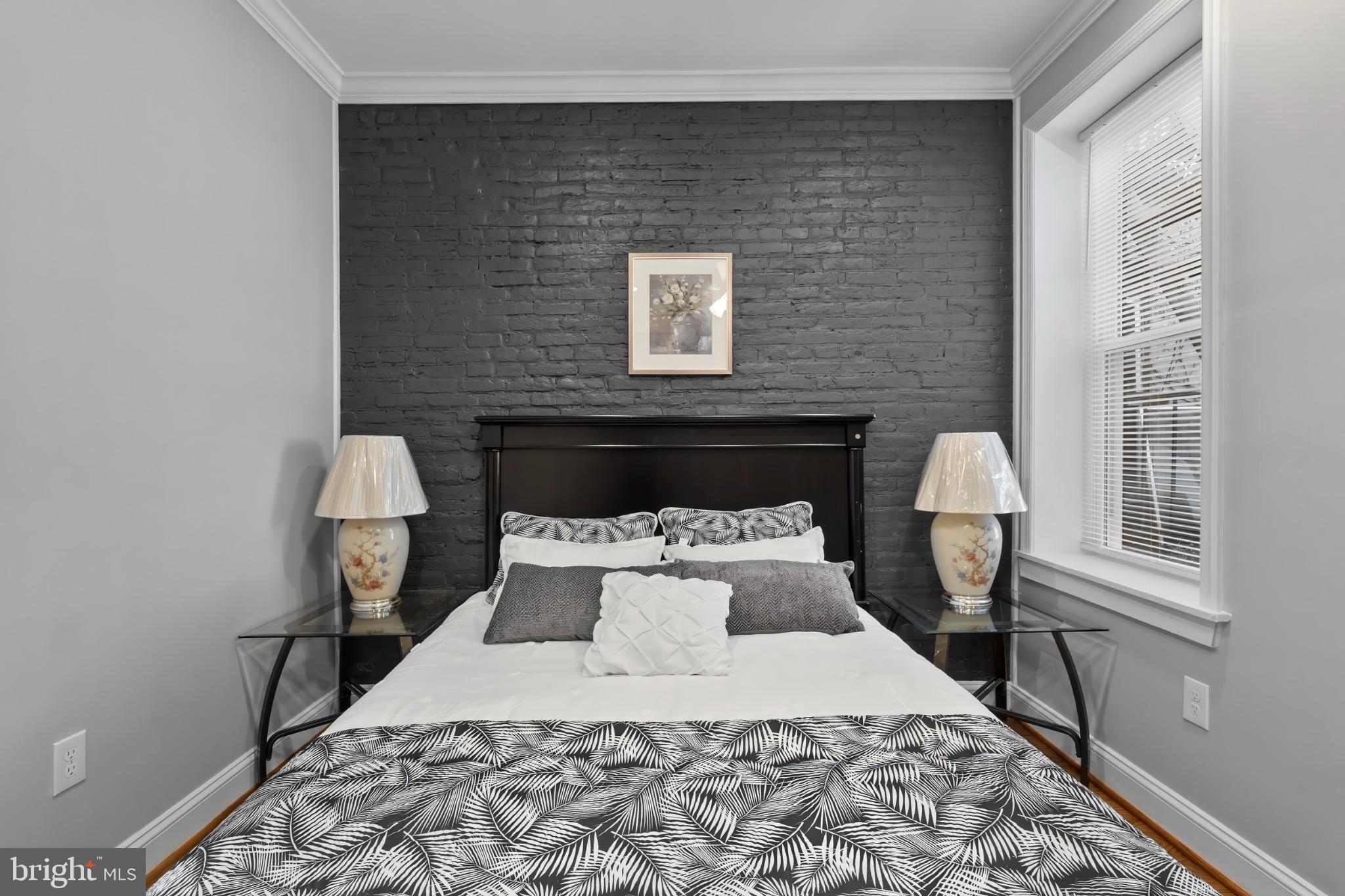 1330 Aisquith Street Baltimore, MD 21202 - Photo 18 of 47 a bed sitting in a bedroom next to a window with lamp