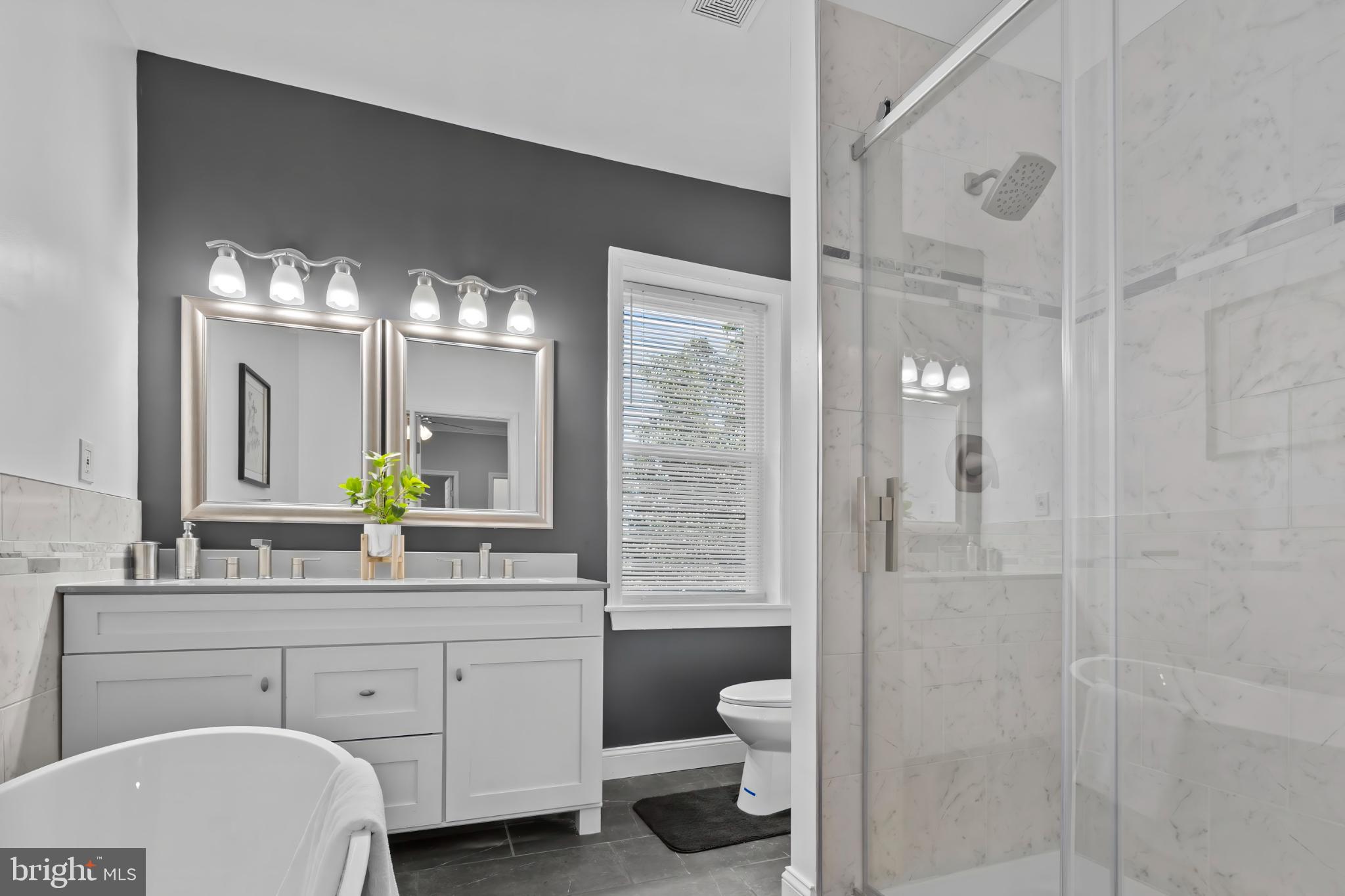 1330 Aisquith Street Baltimore, MD 21202 - Photo 20 of 47 a bathroom with a double vanity sink a toilet a shower and a mirror