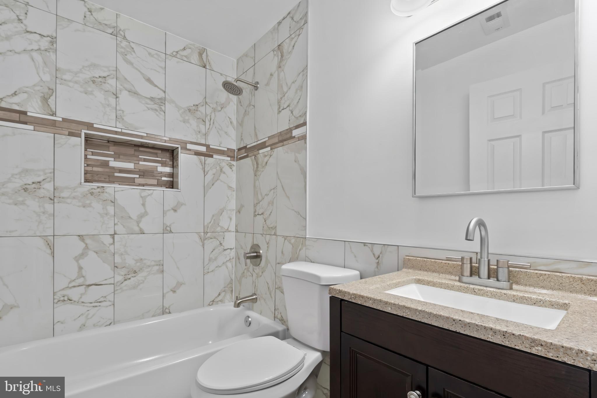 1330 Aisquith Street Baltimore, MD 21202 - Photo 24 of 47 a bathroom with a granite countertop sink toilet and shower