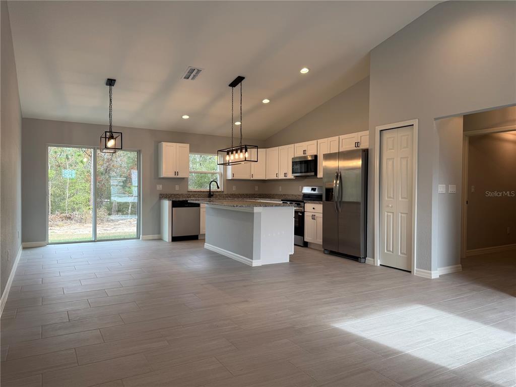 20500 Southwest 54th Street Dunnellon, FL 34431 - Photo 16 of 27 a open kitchen with stainless steel appliances granite countertop a refrigerator a sink a stove and a refrigerator
