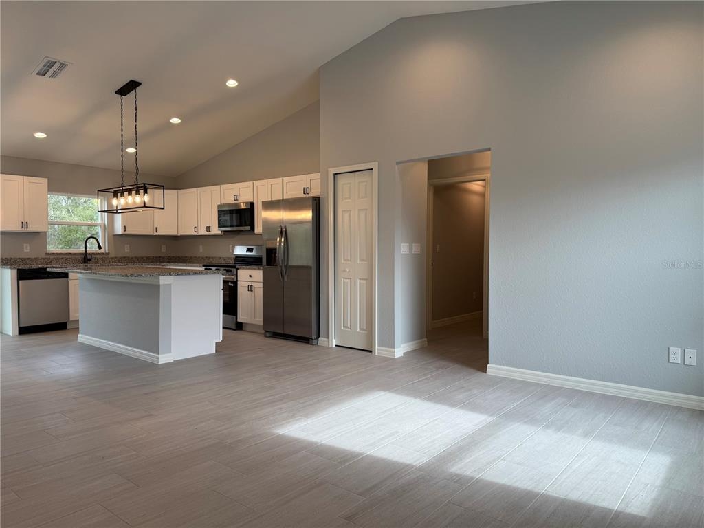 20500 Southwest 54th Street Dunnellon, FL 34431 - Photo 17 of 27 an open kitchen with a refrigerator and a stove top oven