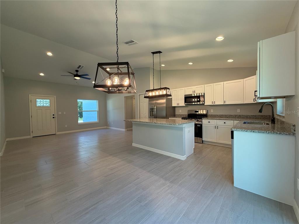 20500 Southwest 54th Street Dunnellon, FL 34431 - Photo 3 of 27 a kitchen with stainless steel appliances granite countertop a stove a sink a refrigerator and a microwave