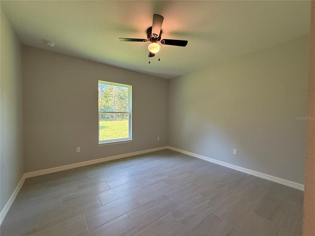 20500 Southwest 54th Street Dunnellon, FL 34431 - Photo 6 of 27 an empty room with window and ceiling fan