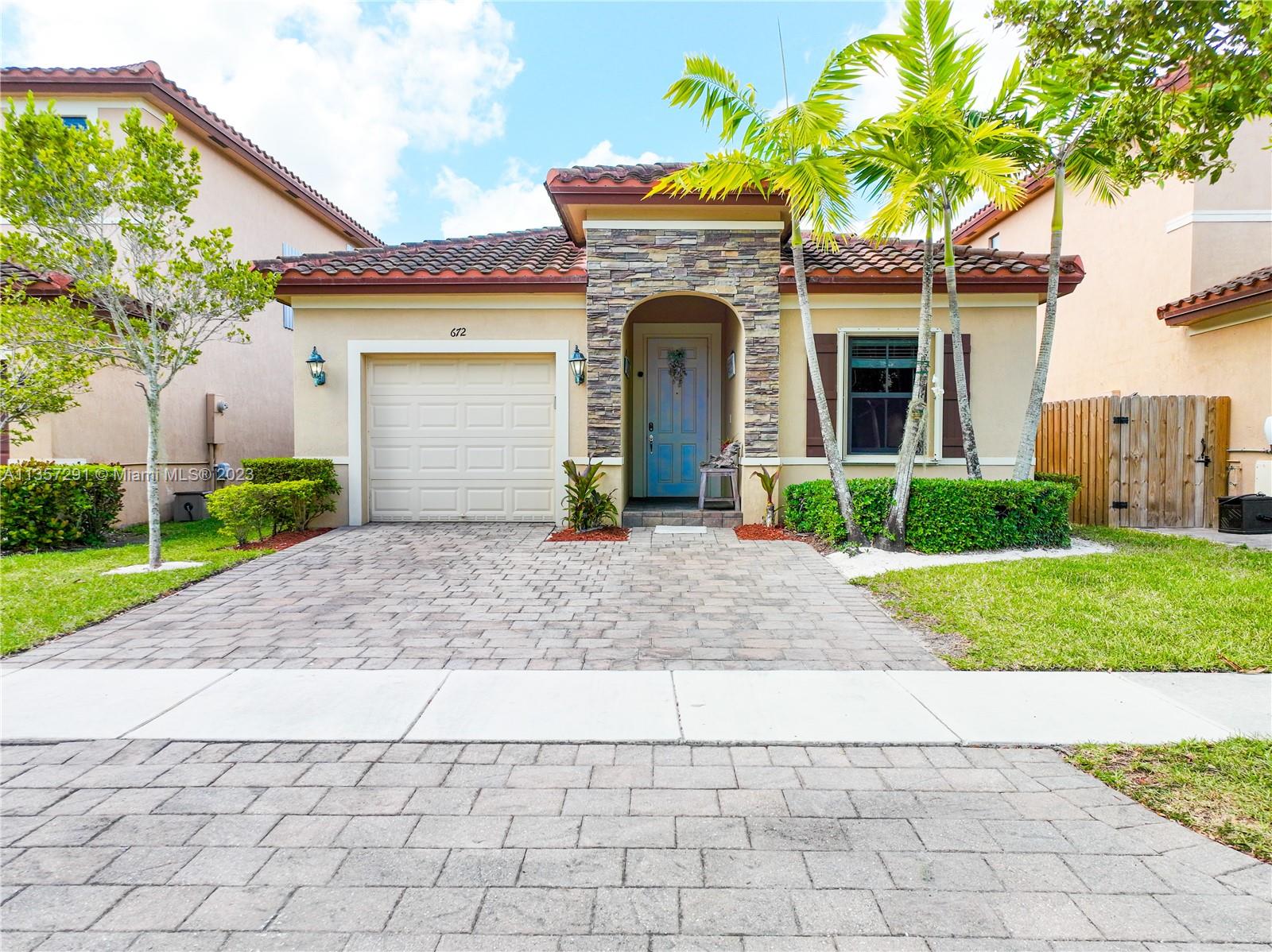 672 Southeast 34th Avenue Homestead, FL 33033 - Photo 1 of 65 a front view of a house with garden