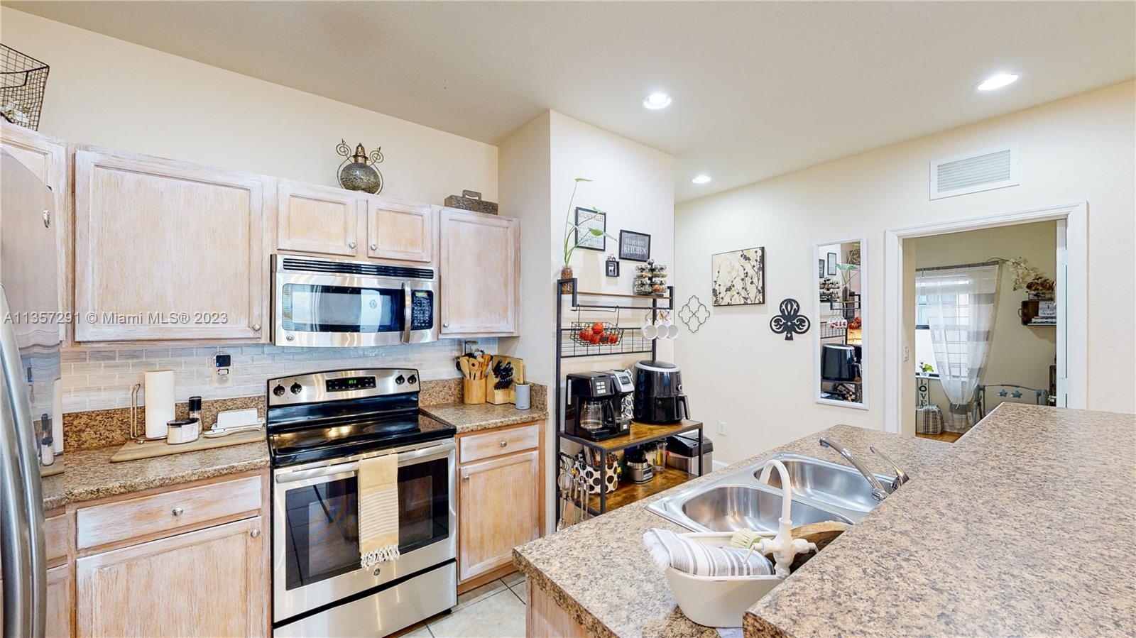 672 Southeast 34th Avenue Homestead, FL 33033 - Photo 17 of 65 a kitchen with stainless steel appliances granite countertop a stove top oven a sink dishwasher and white cabinets