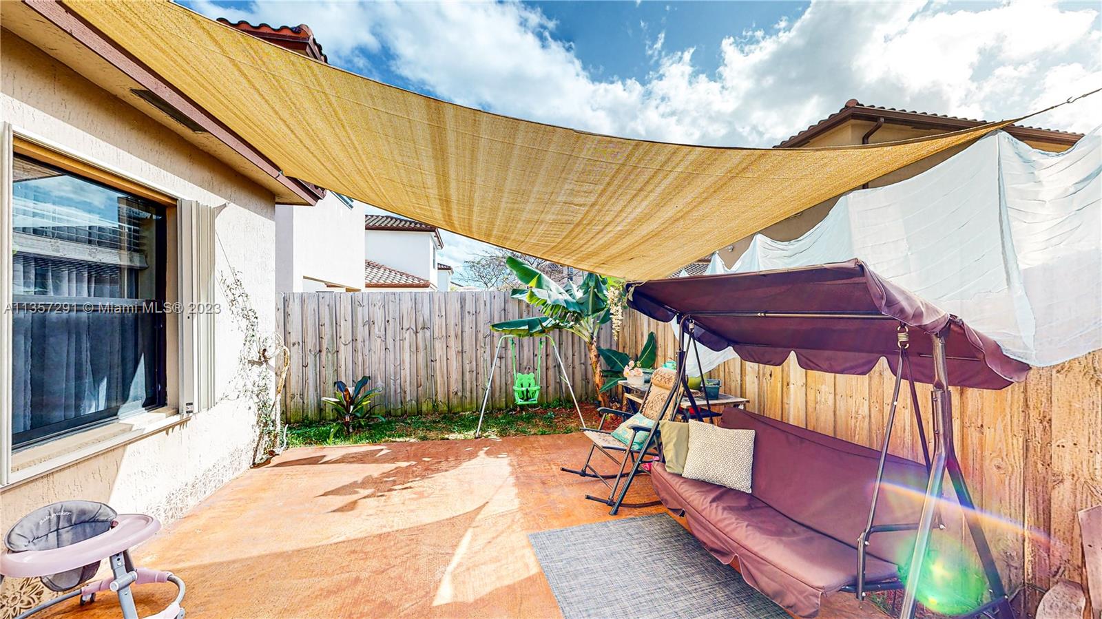 672 Southeast 34th Avenue Homestead, FL 33033 - Photo 36 of 65 a view of a patio with table and chairs under an umbrella