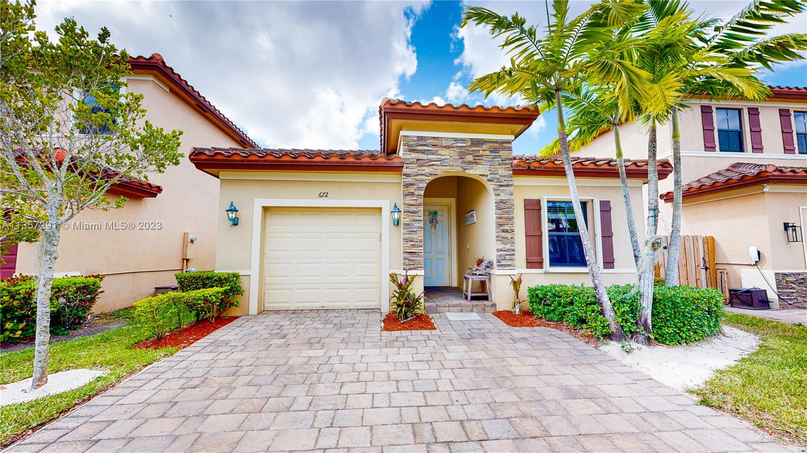 672 Southeast 34th Avenue Homestead, FL 33033 - Photo 4 of 65 a front view of a house with a yard and potted plants