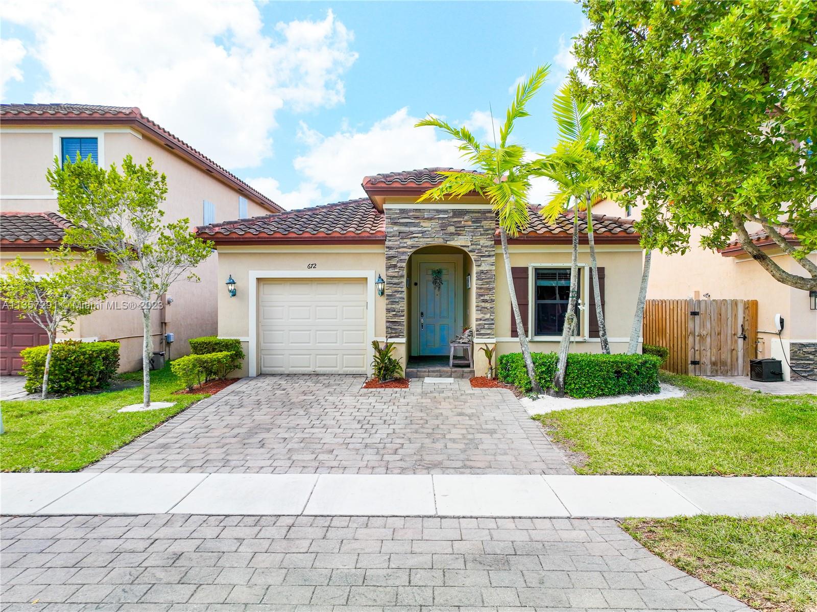 672 Southeast 34th Avenue Homestead, FL 33033 - Photo 46 of 65 a front view of a house with a yard and potted plants