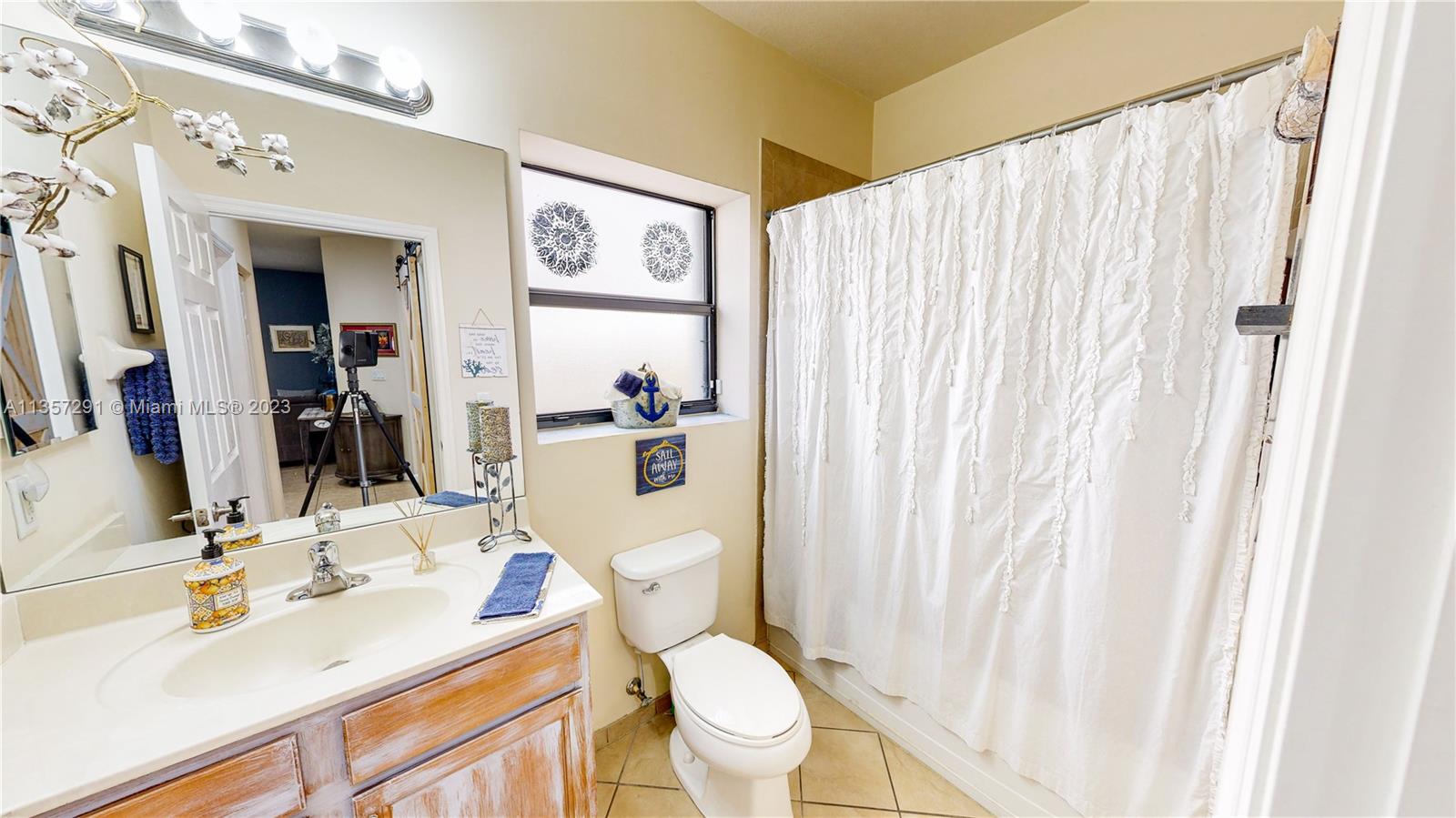 672 Southeast 34th Avenue Homestead, FL 33033 - Photo 10 of 65 a bathroom with a sink a toilet and shower curtain