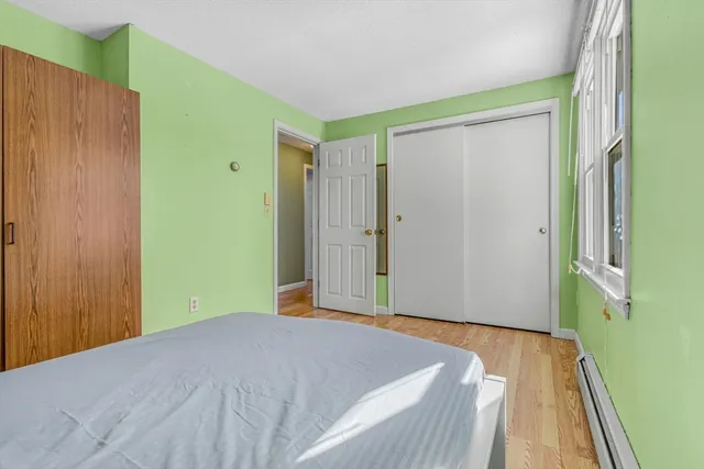 a bedroom with a bed and wooden floor