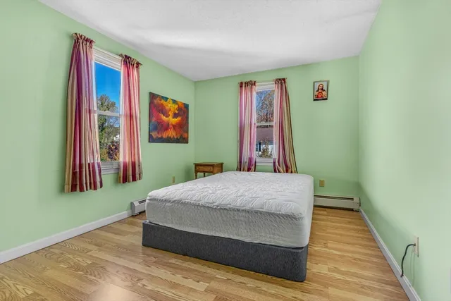 a bedroom with a bed and a painting on the wall