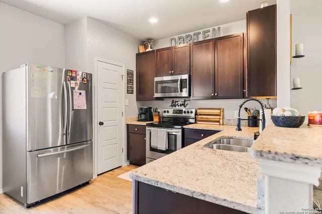a kitchen with granite countertop stainless steel appliances and wooden cabinets