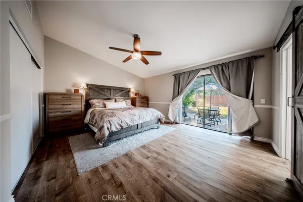 a bedroom with a bed windows and a chandelier