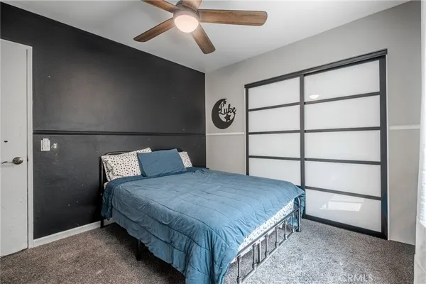 a bedroom with a bed and a ceiling fan