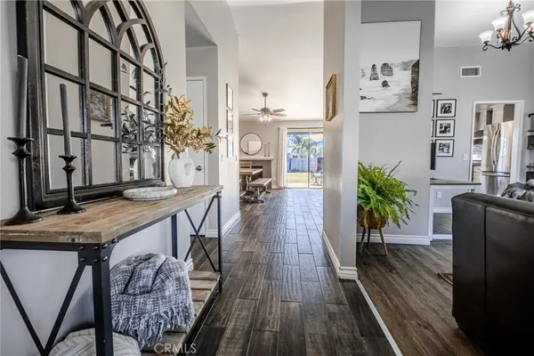 a view of a hallway with furniture and wooden floor