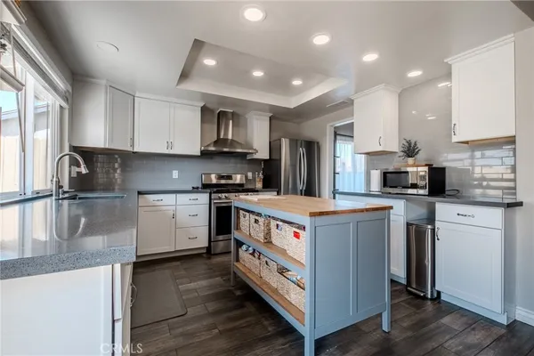 a kitchen with kitchen island granite countertop a sink and a stove top oven