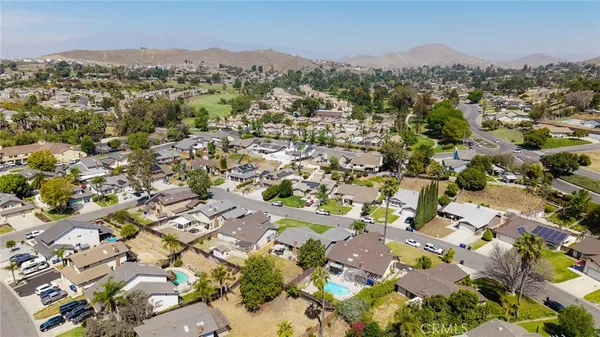 an aerial view of residential houses with outdoor space and trees