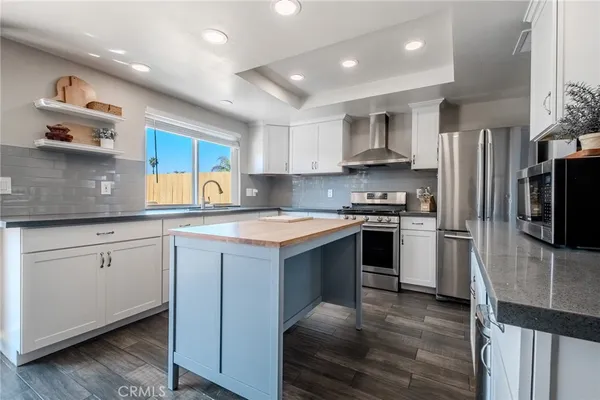 a kitchen with stainless steel appliances granite countertop a refrigerator and a stove top oven