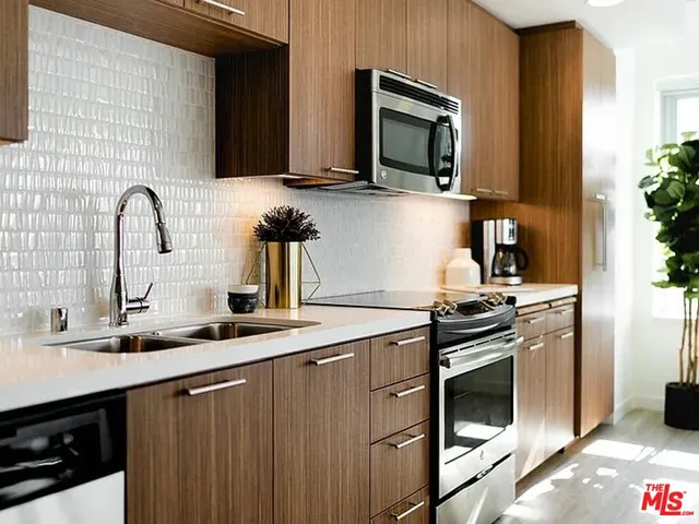 a kitchen with stainless steel appliances a sink stove and microwave