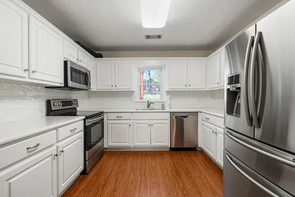 a kitchen with granite countertop stainless steel appliances and wooden cabinets