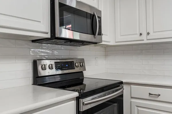 a stove top oven sitting inside of a kitchen