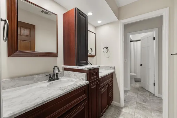 a bathroom with a granite countertop sink and a mirror