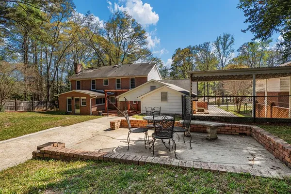a view of a house with backyard and sitting area