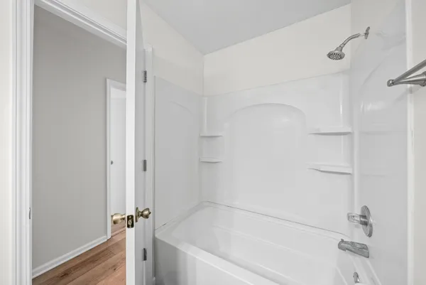 a white bath tub sitting next to a shower